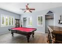 Bright game room featuring a red billiard table, wood-look tile flooring, and window shutters at 1904 E Grand Canyon Dr, Chandler, AZ 85249