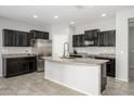 Well-lit kitchen featuring dark cabinets, stainless steel appliances, and a granite countertop island at 25951 W Piute Ave, Buckeye, AZ 85396