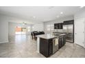 Open kitchen features dark cabinets, granite countertops, and an island with views of the dining area at 25951 W Piute Ave, Buckeye, AZ 85396