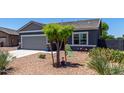 Single-story home displaying an attached two-car garage and low-water, desert-style landscaping at 30388 N Opal Dr, San Tan Valley, AZ 85143