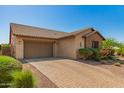 A long, brick driveway leads to a two-car garage attached to a single-Gathering home at 3331 N Acacia Way, Buckeye, AZ 85396