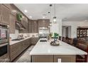 Gourmet kitchen features an extended island counter with seating and flowers at 3331 N Acacia Way, Buckeye, AZ 85396