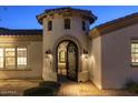 Close up of the entrance tower with an iron gate, paver pathway, and manicured bushes at 35556 N 87Th Pl, Scottsdale, AZ 85266