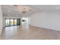 Spacious living room with light wood floors, recessed lighting, and sliding glass doors to the backyard at 4246 E Mulberry Dr, Phoenix, AZ 85018