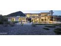 Elegant modern home at twilight featuring a fire pit, and seamless indoor-outdoor living at 4451 E Joshua Tree Ln, Paradise Valley, AZ 85253