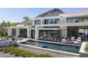 Modern home featuring a tranquil pool, sleek lounge area, and mountain views at 4451 E Joshua Tree Ln, Paradise Valley, AZ 85253