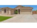 Beautiful house with desert landscaping, artificial grass, and two-car garage on a sunny day at 7008 W Southgate Ave, Phoenix, AZ 85043