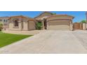 Beautiful house with desert landscaping, artificial grass, and two-car garage on a sunny day at 7008 W Southgate Ave, Phoenix, AZ 85043
