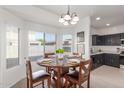 Bright dining area with a wooden table, chandelier, and an abundance of natural light at 7227 S 13Th Way, Phoenix, AZ 85042