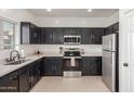 Modern kitchen with stainless steel appliances, quartz countertops, and dark wood cabinets at 7227 S 13Th Way, Phoenix, AZ 85042