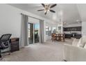Open-concept living space features carpet floors, natural light, and access to the backyard at 7227 S 13Th Way, Phoenix, AZ 85042