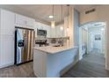 Kitchen boasts stainless appliances, white cabinets, and an island with pendant lighting at 9600 N 96Th St # 171, Scottsdale, AZ 85258