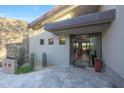 Modern entryway featuring stone accents, desert landscaping, and a glimpse of the home's open-concept interior at 10651 E Fernwood Ln, Scottsdale, AZ 85262