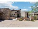 Striking exterior showcases stone architecture, xeriscaping, and a private driveway, blending modern design with desert charm at 10651 E Fernwood Ln, Scottsdale, AZ 85262