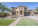Charming two-story home with a tile roof, two-car garage, and lush, low-maintenance landscaping enhances the curb appeal at 10925 E Toluca Ave, Mesa, AZ 85212
