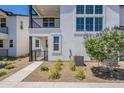 Modern home with multiple windows and a small decorative yard with bushes and a tree at 11300 N Casa Dega Dr # 1005, Surprise, AZ 85388
