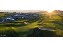 Scenic golf course view at sunset featuring lush green grass, sand traps, and homes in the background at 11300 N Casa Dega Dr # 1005, Surprise, AZ 85388