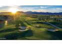 Scenic golf course view featuring lush green grass, sand traps and mountain views in the background at 11300 N Casa Dega Dr # 1005, Surprise, AZ 85388
