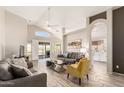Bright living room with tile flooring, neutral paint, and an archway to the kitchen at 11669 W Pine Mountain Ct, Surprise, AZ 85378