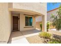 Inviting covered entryway with a dark wood door and stone accents at 18514 W Williams Rd, Surprise, AZ 85387