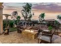 Relaxing backyard space featuring a stone fire pit, comfortable seating, mature landscaping, and a tranquil ambiance at 20784 W Minnezona Ave, Buckeye, AZ 85396
