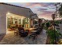 Beautiful outdoor living area with a cozy fire pit, dining table, and lush landscaping for relaxation and entertainment at 20784 W Minnezona Ave, Buckeye, AZ 85396