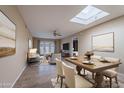 Inviting living room featuring a skylight, a dining table, comfortable seating, and stylish decor at 2527 E Villa Theresa Dr, Phoenix, AZ 85032