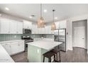 Bright kitchen featuring white cabinets, subway tile backsplash, stainless appliances, and an island at 2562 N Springfield St, Buckeye, AZ 85396