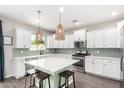 Spacious kitchen with an island, stainless appliances, subway tile backsplash, and ample cabinet space at 2562 N Springfield St, Buckeye, AZ 85396