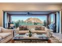 Living room featuring a comfortable sofa, mountain views, and natural light from the large windows at 27000 N Alma School Pkwy # 1033, Scottsdale, AZ 85262
