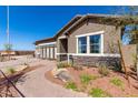 Inviting single-story home featuring well-manicured landscaping and stone accents under a bright blue sky at 27647 N 176Th Dr, Surprise, AZ 85387