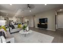 Open-concept living room featuring neutral tones, modern furniture, and seamless flow to the kitchen at 27647 N 176Th Dr, Surprise, AZ 85387