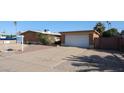 A single story brick home with desert landscaping, a long driveway, and a one car garage in a sunny setting at 2933 W Del Mar Ln, Phoenix, AZ 85053