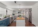 Bright kitchen with stainless steel appliances, center island with wood countertop, and updated cabinetry at 3222 E Cortez St, Phoenix, AZ 85028