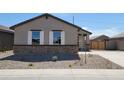 Attractive single-story home featuring stone veneer, white shutters, a desert-scape yard, and a concrete sidewalk at 328 S San Christo Ln, Casa Grande, AZ 85194