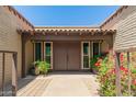 Inviting front entry with double doors, tiled overhang, colorful flowering plants, and brick pavers at 3512 S Elm St, Tempe, AZ 85282