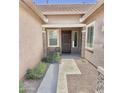 Inviting front entryway with a dark wood door, neutral paint, decorative stone accents and drought-tolerant landscaping at 4956 S Leisure Way, Gilbert, AZ 85298