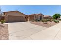 Lovely home showcasing a spacious driveway, two-car garage, and low-maintenance desert landscaping at 5919 W Straight Arrow Ln, Phoenix, AZ 85083