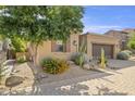 Front yard of a single-story home featuring desert landscaping, a tree, and a brick driveway at 6231 E Mark Way # 14, Cave Creek, AZ 85331