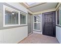 Entryway featuring a solid door, windows with blinds, and a security door at 7132 N 63Rd Dr, Glendale, AZ 85301