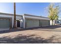 Row of garages with neutral paint, each featuring roll-up doors and trees at 7132 N 63Rd Dr, Glendale, AZ 85301