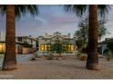 Charming home at dusk, highlighting the beautifully landscaped front yard and inviting windows at 725 W Portland St, Phoenix, AZ 85007