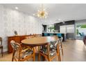 Dining area boasts modern light fixture, stylish wallpaper, and seamless flow to kitchen at 7533 N 8Th St, Phoenix, AZ 85020