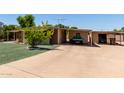 Exterior view showcasing carport, lush lawn, and mature tree in front of the residence at 8632 E Delilah Ave, Mesa, AZ 85208
