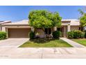 Charming single-story home with a well-manicured lawn, mature landscaping, and a two-car garage at 9002 W Caribbean Ln, Peoria, AZ 85381