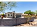 Street view of modern home featuring a contemporary design, gray garage door, and a basketball hoop in the driveway at 1005 E Weldon Ave, Phoenix, AZ 85014