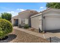 Well-maintained home showcasing a tidy front yard, desert landscaping, and a charming entryway with a blue front door at 1703 E Palo Blanco Way, Gilbert, AZ 85296