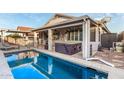Inviting backyard featuring a pool, spa, covered patio, and outdoor seating area at 18080 W Spencer Dr, Surprise, AZ 85374