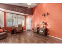 Comfortable living room with wood floors, a ceiling fan, and a view to the front yard at 18080 W Spencer Dr, Surprise, AZ 85374