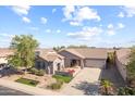 Inviting single-story home with a long driveway, attached garage, and appealing landscaping at 22205 W Ashleigh Marie Dr, Buckeye, AZ 85326